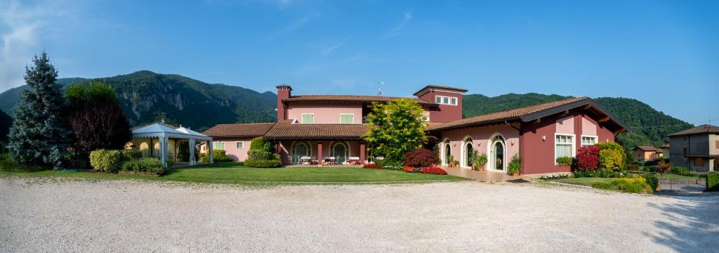 a large pink house with a driveway at Hotel Al Poggio Verde in Barghe