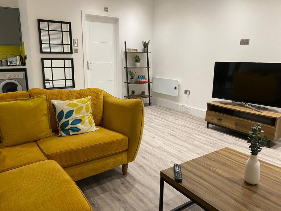 Flat 2, 3 bed New York inspired apartment-Swan F2 في سوانسي: غرفة معيشة بها أريكة صفراء وتلفزيون