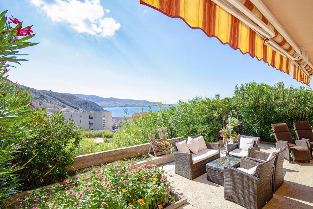 patio z krzesłami i kwiatami oraz widokiem na ocean w obiekcie Durdica beautiful garden with fantastic sea and mountain views w mieście Metajna