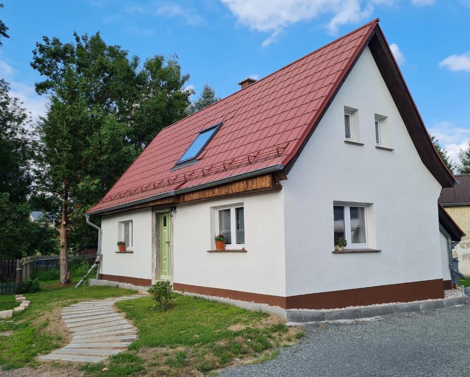 a white house with a red roof at Ferienhaus Landpause in Frohburg
