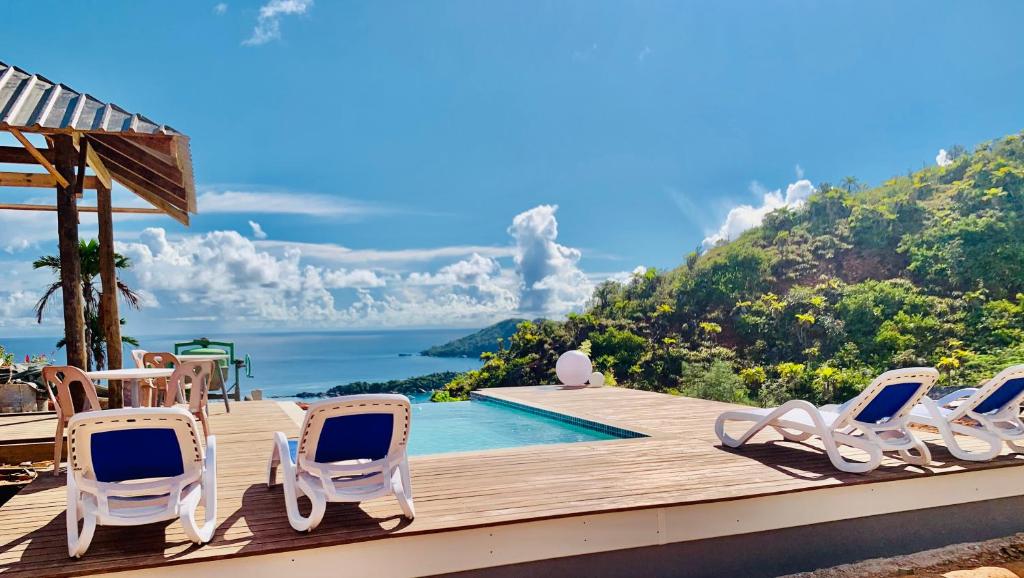 a group of chairs sitting on a deck next to a swimming pool at Terrasse Sur Lazio in Anse Lazio