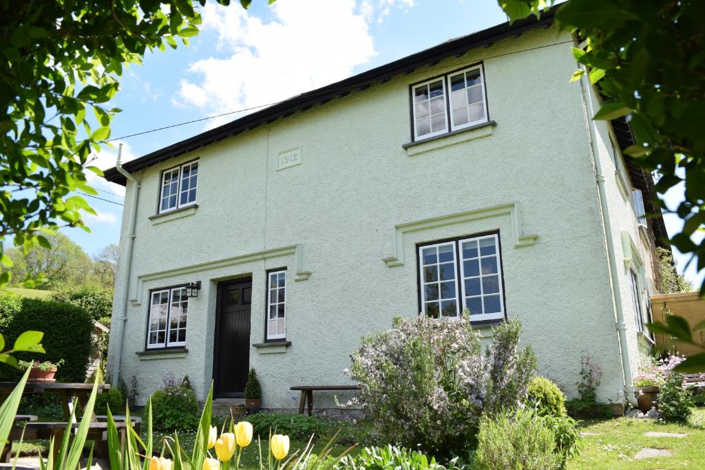 a white house with a black door and windows at Cedra Cottage - Vintage Country Hideaway in Axminster