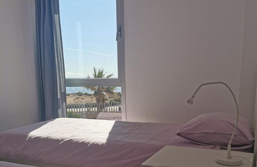 a bedroom with a bed with a window and a lamp at Modern sea view duplex with parking in El Médano