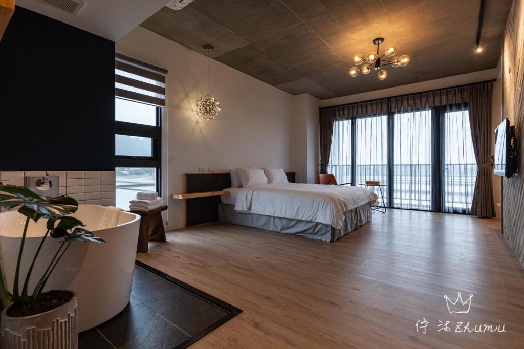 1 dormitorio con cama y ventana grande en Zhumu B&B, en Xingjian