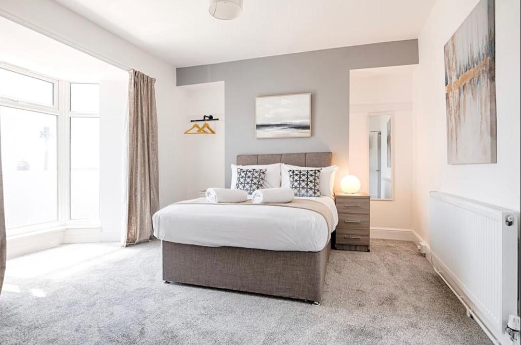 a bedroom with a bed and a large window at 4 Bed Executive Style House - Near City Centre in Swansea