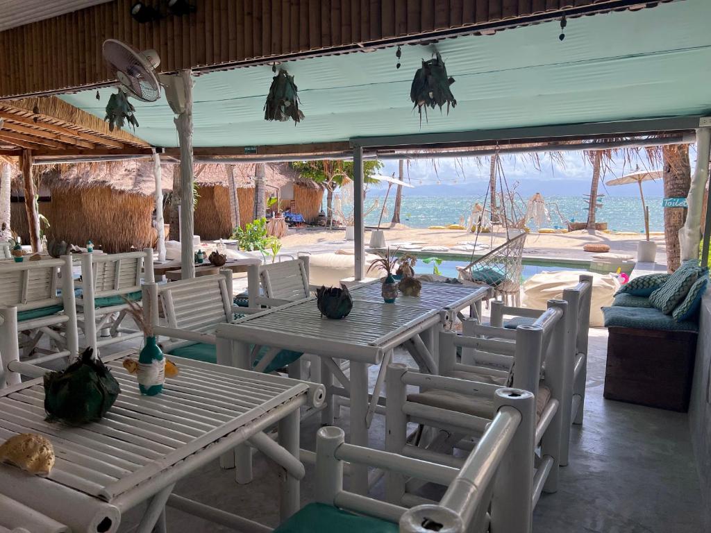 a table and chairs with a view of the ocean at Sea Love Beach Bar & Bungalows in Ban Tai
