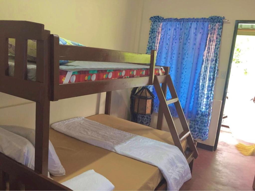 two bunk beds in a room with a window at The Family Farm Stay in Cauayan City