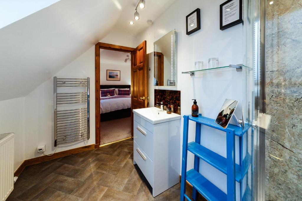 a bathroom with a sink and a room with a bed at Ceol na Mara Guest House in Tarbert