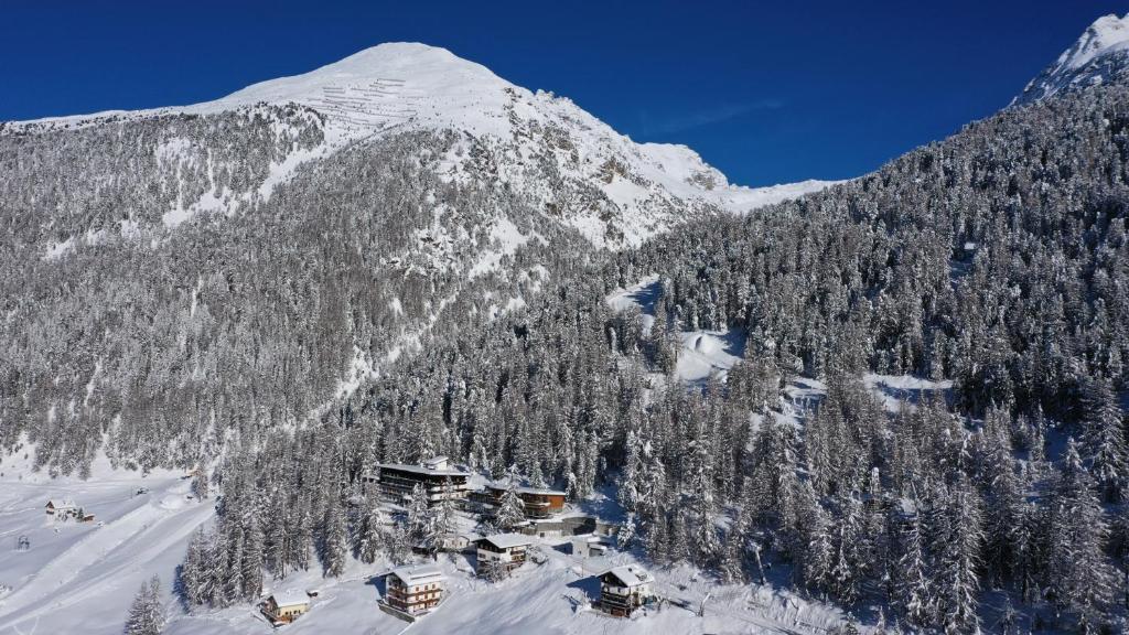 a snow covered mountain with a ski lodge in front of it at Hotel Zebru in Solda