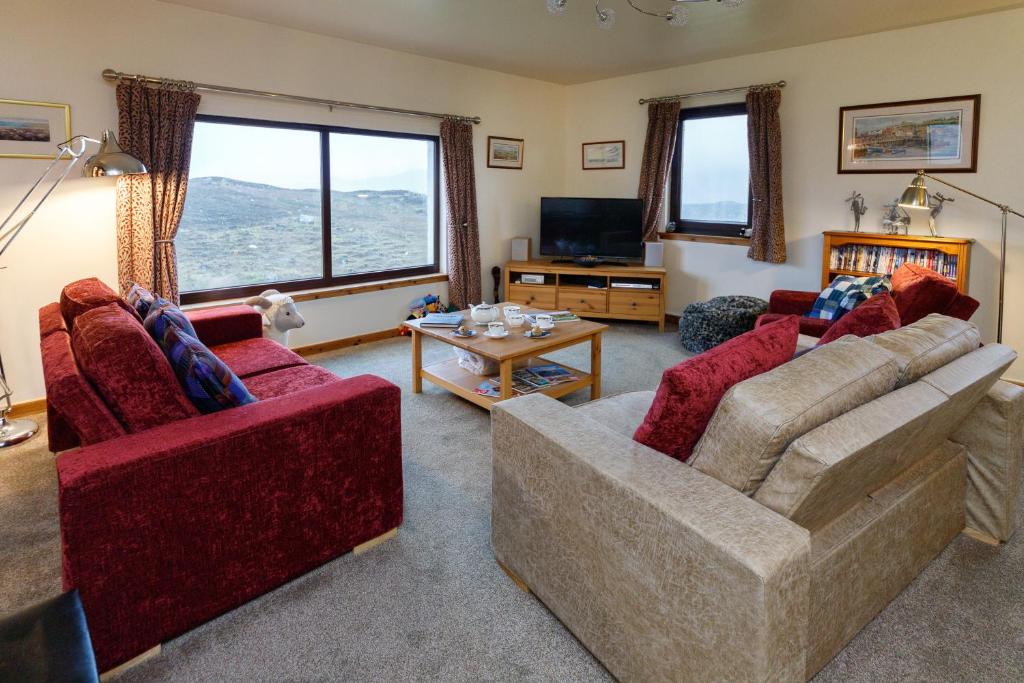 a living room with two couches and a tv at Ceol na Mara Guest House in Tarbert