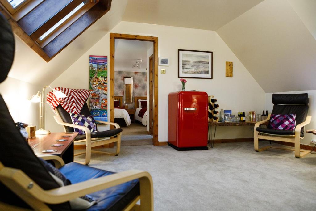 a living room with a red refrigerator and chairs at Ceol na Mara Guest House in Tarbert