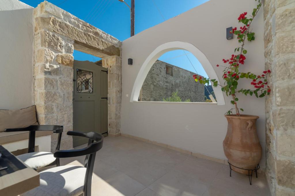 a room with a window and a vase with a plant at Stonehouse South Crete in Vóroi