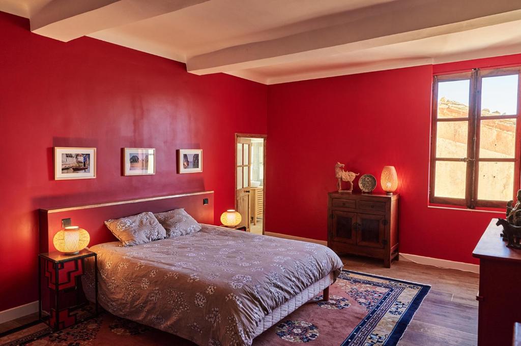 a bedroom with red walls and a bed and a window at Chateau de Beaucouse in Thoard