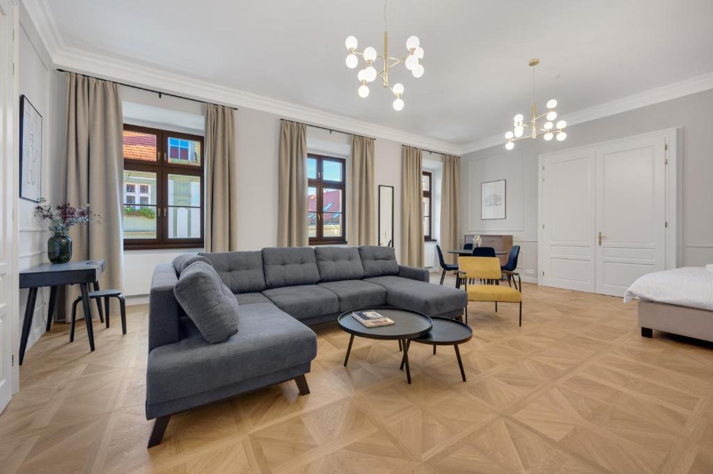 ein Wohnzimmer mit einem Sofa und einem Tisch in der Unterkunft Palace Apartments in Bratislava
