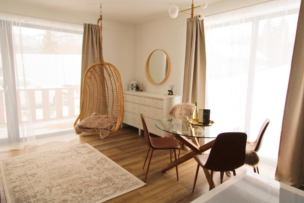 comedor con mesa de cristal y sillas en Björg Apartment & Sauna en Donovaly