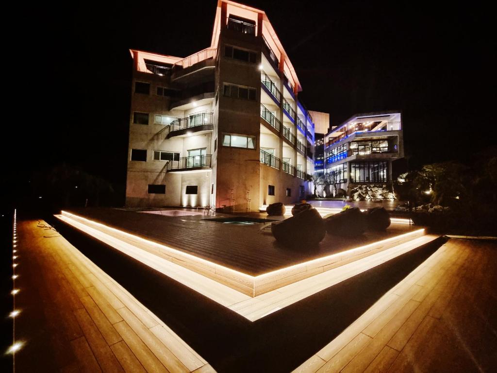 a large building with lights in front of it at night at J View Hotel in Seogwipo