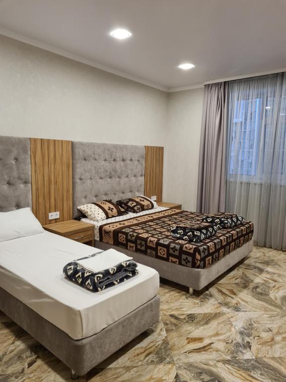 a hotel room with two beds and a window at Akropol in Gelendzhik