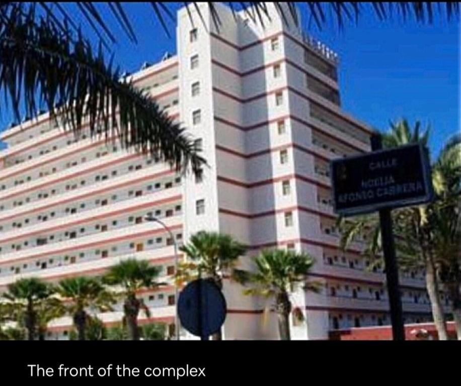 a large white building with a sign in front of it at El Dorado Las Americas WiFi Pool in Arona