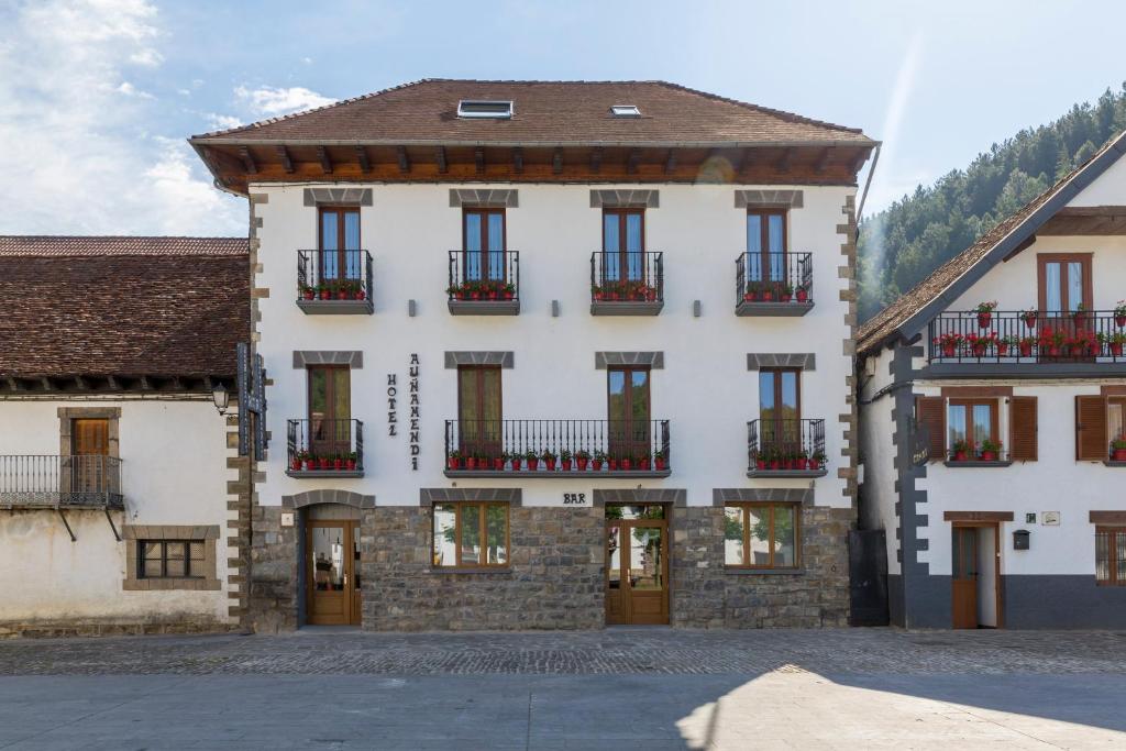 a large white building with balconies on a street at Hotel Rural Auñamendi in Ochagavía