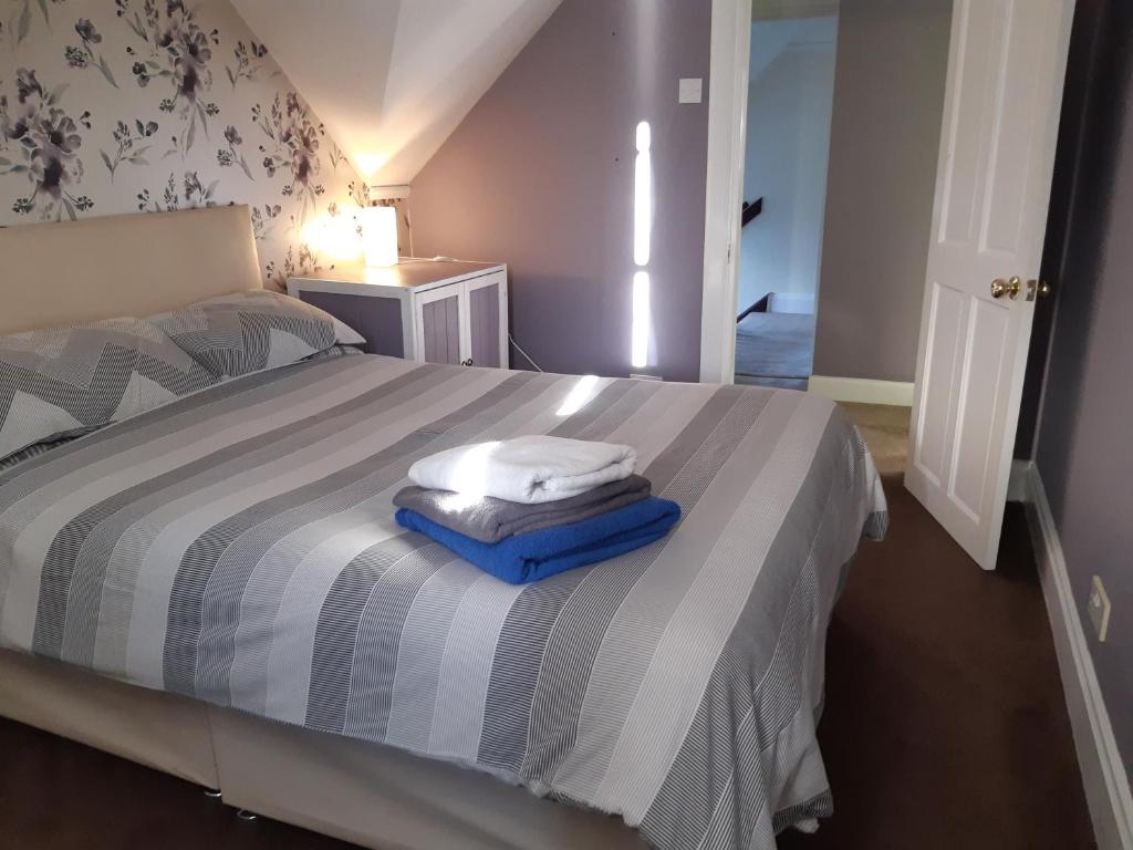 1 dormitorio con 1 cama con toallas en Carvetii - Halite House - 3 bed House sleeps up to 5 people, en Tillicoultry