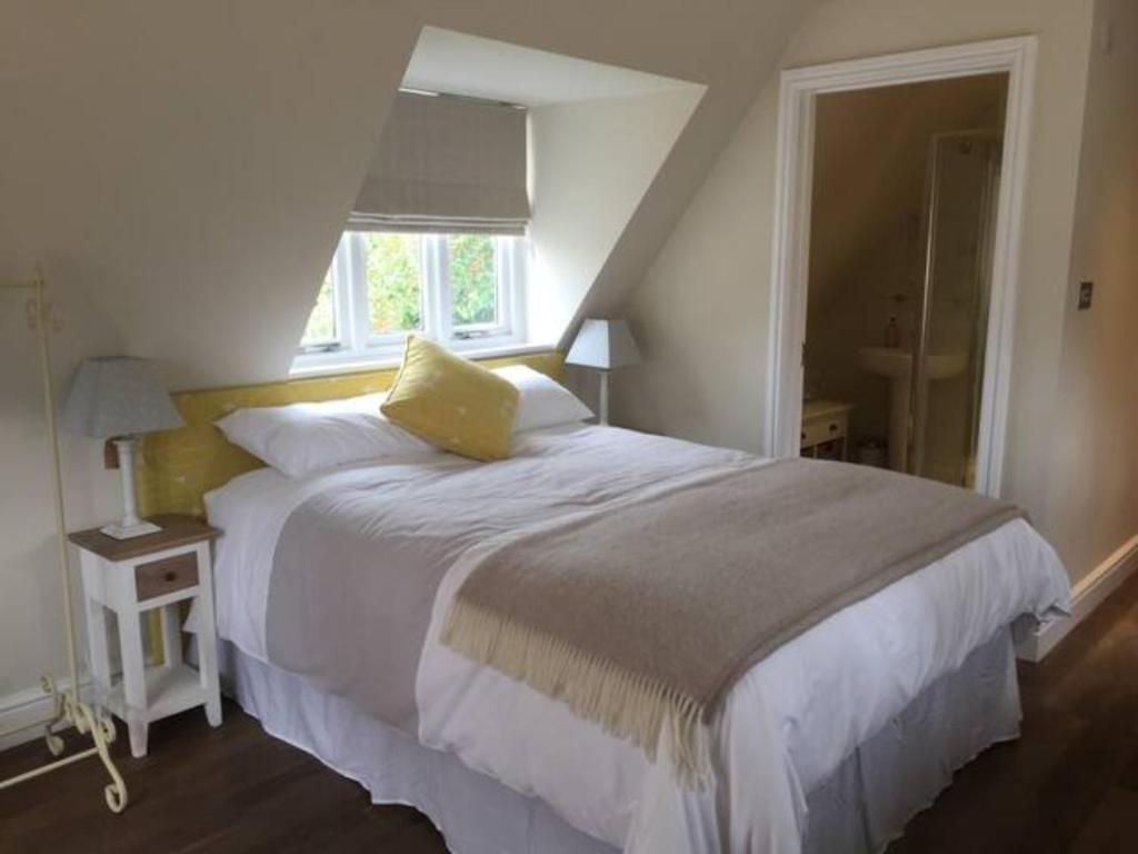 Un dormitorio con una cama grande y una ventana en The Brigstock Snug, en Brigstock