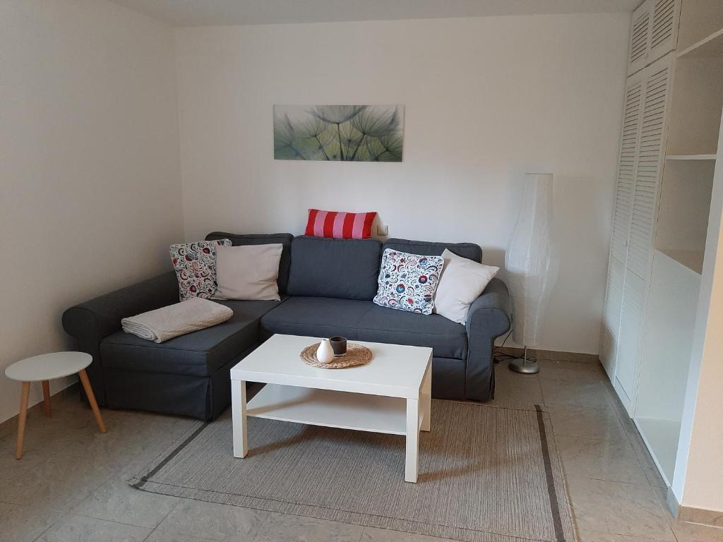 uma sala de estar com um sofá azul e uma mesa em Fewo Bernhardt " App. 2 " em Scharbeutz