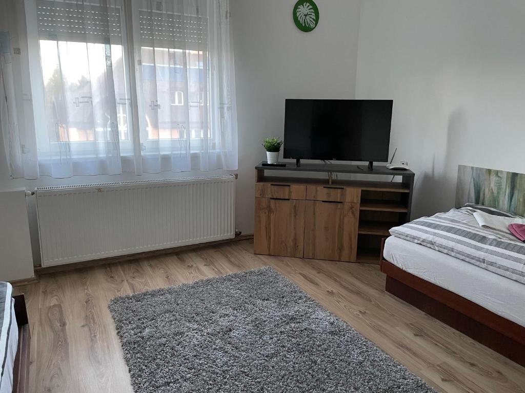 a bedroom with a flat screen tv and a bed at Patak pihenő in Mende