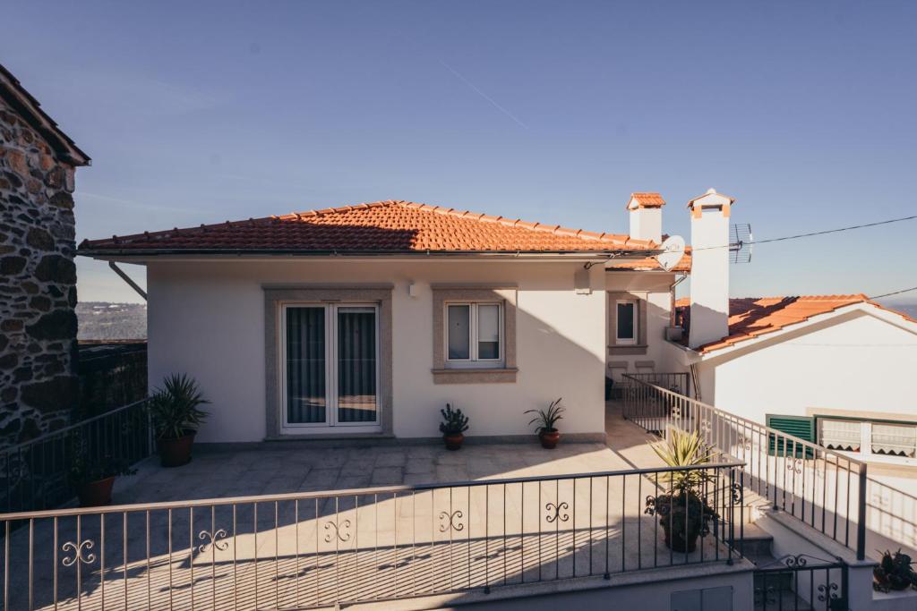 Cette maison blanche dispose d'un balcon avec une clôture. dans l'établissement Cabanelas Country House - Casa do Luís, à Vale de Cambra