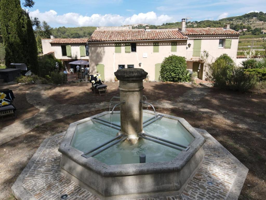 a fountain in a yard in front of a house at Mas Misajail in Le Castellet