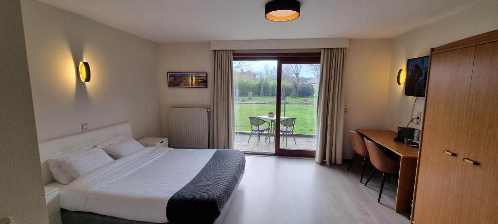 a hotel room with a bed and a desk and a window at Hotel Westendia in Middelkerke