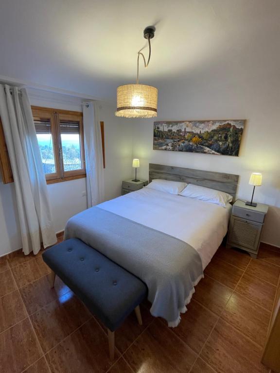 Un dormitorio con una gran cama blanca y una lámpara de araña. en Casa Grasa, en Radiquero
