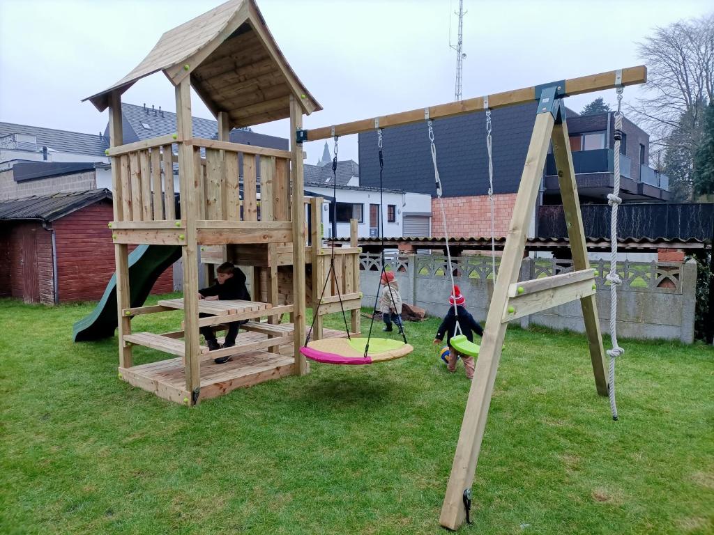 zwei Kinder spielen auf einem Spielplatz mit Holzspielstruktur in der Unterkunft Moodraz vakantiehuis centrum Peer in Peer