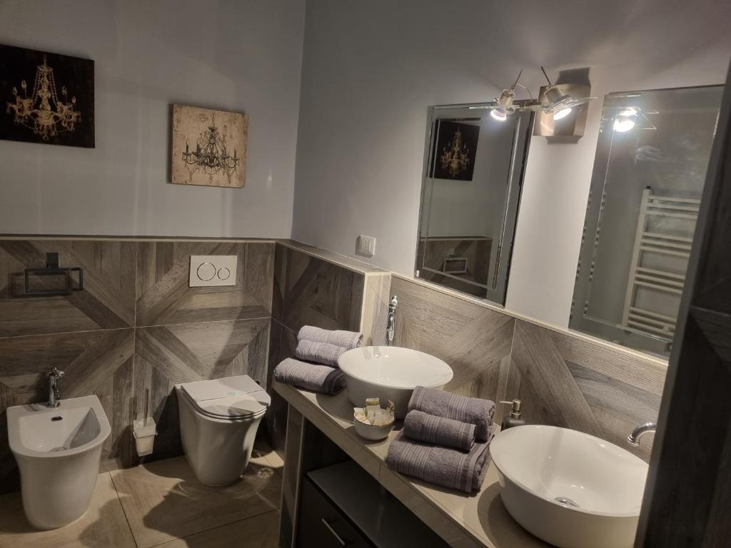 a bathroom with two sinks and a toilet and a mirror at La Cittadella10 in Turin