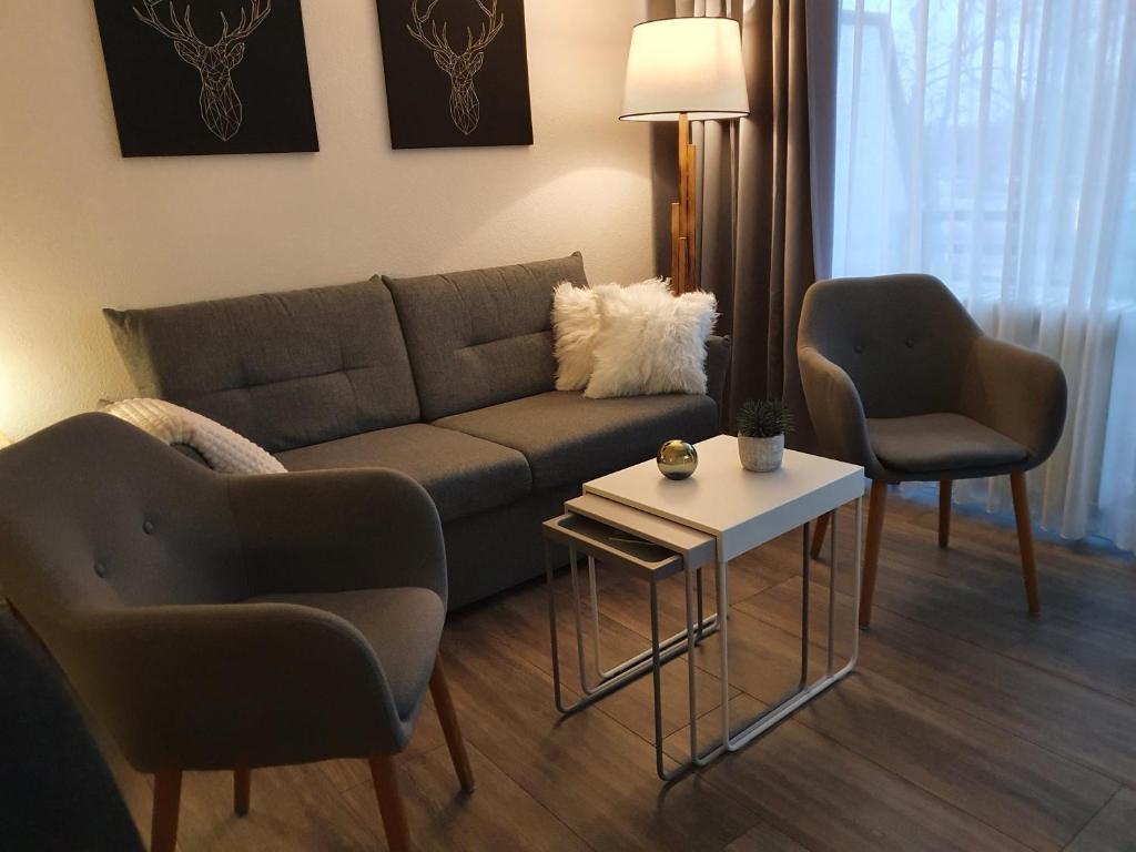 a living room with a couch and two chairs at Apartment am Bocksberg in Hahnenklee-Bockswiese