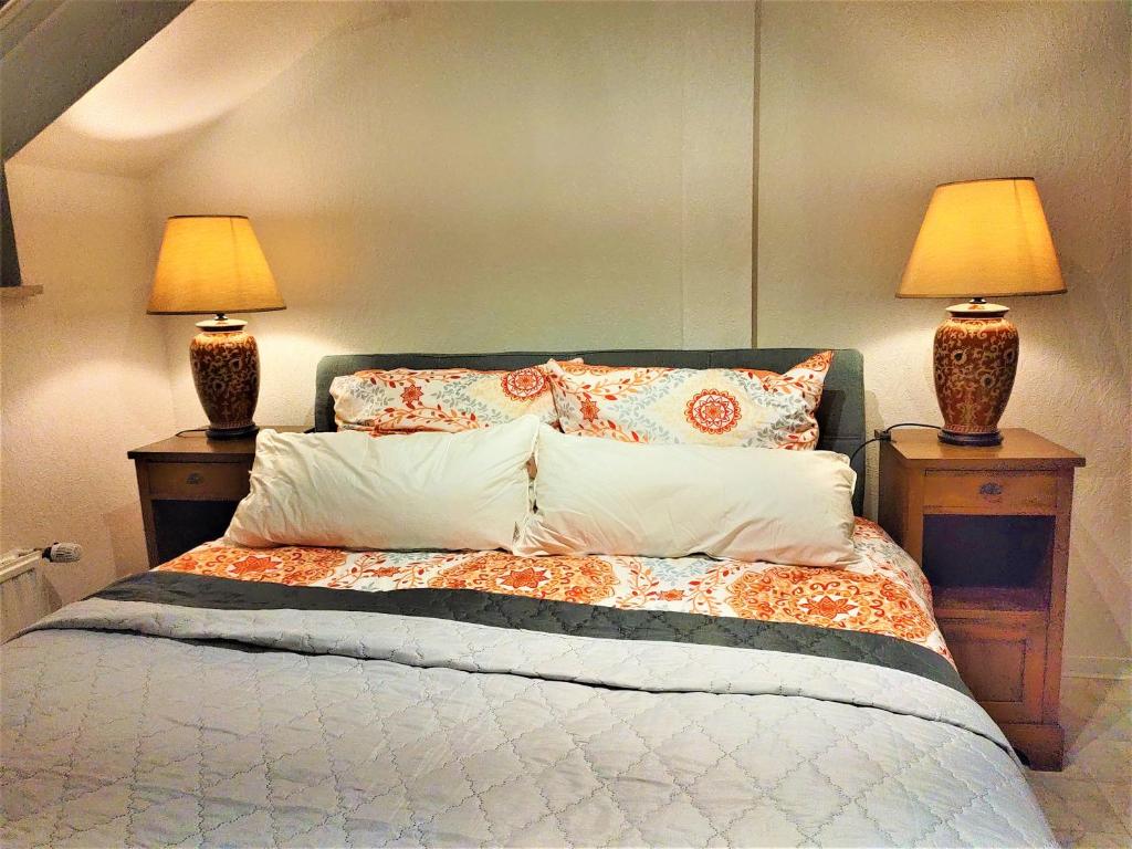 ein Schlafzimmer mit einem Bett mit zwei Lampen an zwei Tischen in der Unterkunft Golden Treasure Superior in Münster