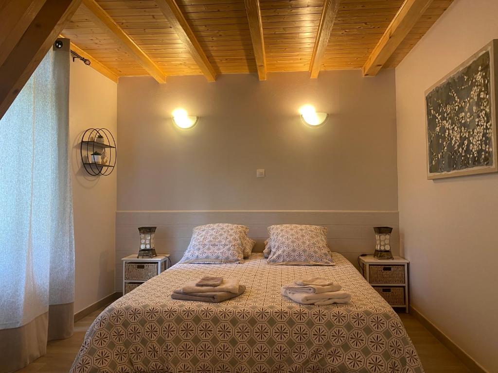 a bedroom with a bed with two towels on it at Le Cocon de Curson chambre d'hôtes in Chanos-Curson