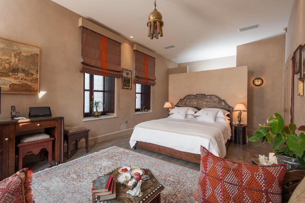 a large bedroom with a bed and a piano at La Maison Ottomane in Chania Town