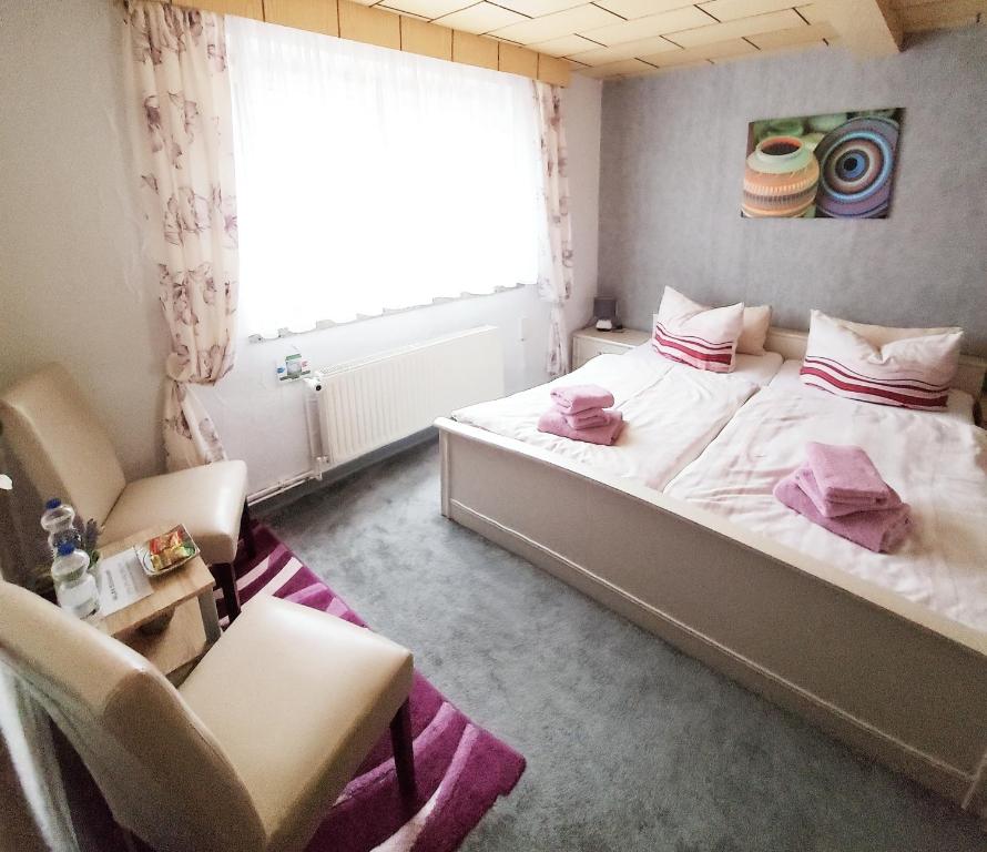 1 dormitorio con 1 cama, 2 sillas y ventana en Ferienhaus Strauss nahe der Kyffhäuser Therme, en Bad Frankenhausen