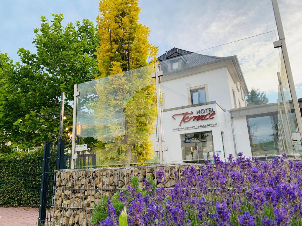 einen Laden mit lila Blumen vor einem Gebäude in der Unterkunft Hotel Terrace in Bettendorf