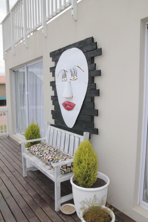 un banco en un porche con una pintura de una mujer en Allalapstix, en Reebok