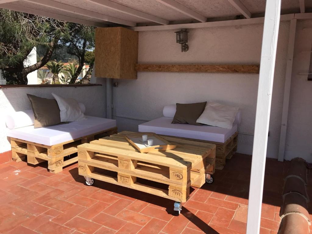 a patio with two couches and a table and chairs at Apartamento Centrico con Terraza in Platja  d'Aro