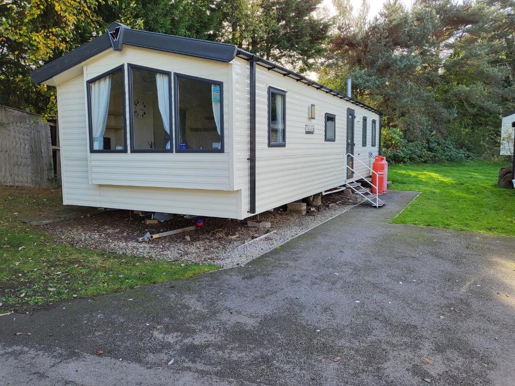 a white tiny house parked in a yard at Caravan Kensington 46 at Marton Mere Blackpool in Blackpool