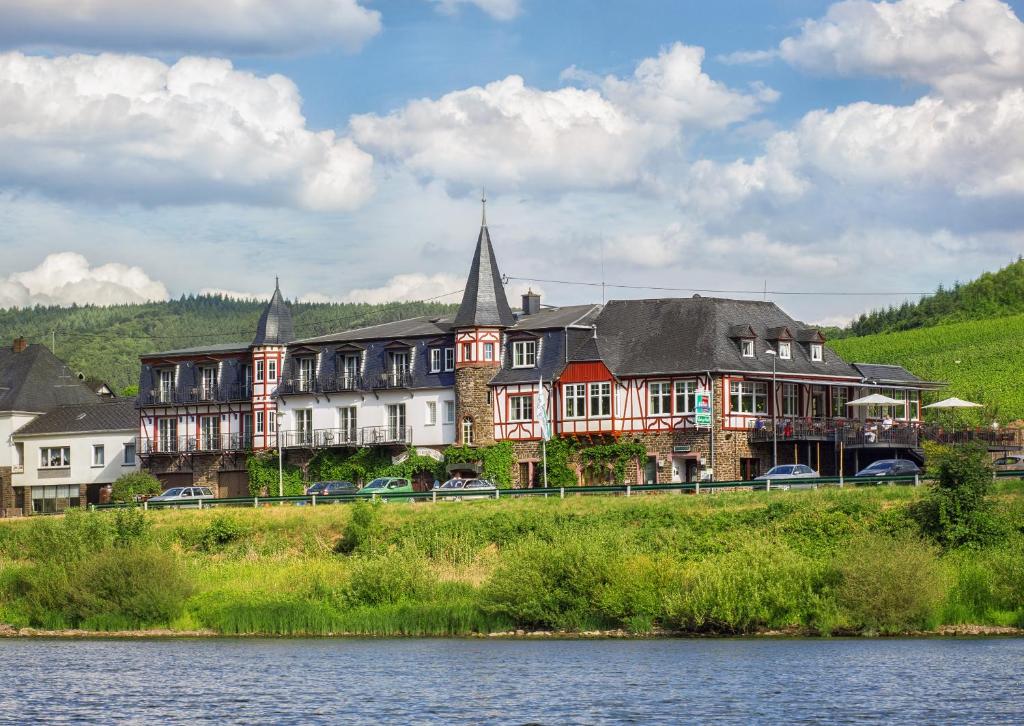 um grande edifício ao lado de uma massa de água em Hotel Filla Andre em Ernst