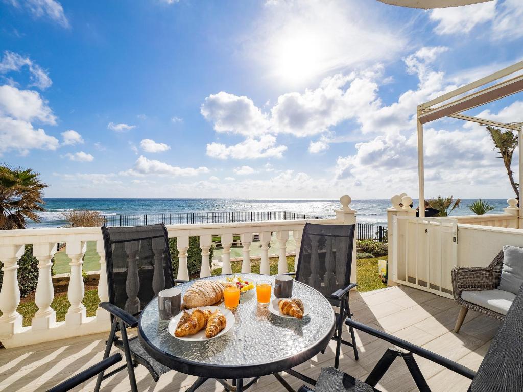a table on a balcony with a view of the ocean at Apartment on Beach Mijas in Mijas Costa