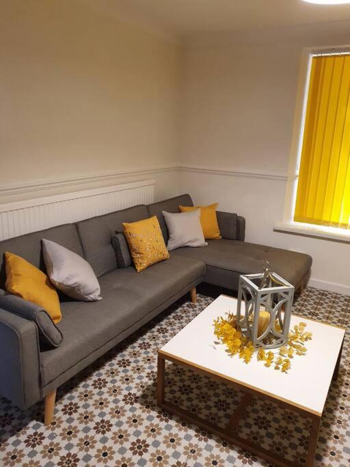 uma sala de estar com um sofá e uma mesa de centro em Fairoak Retreat em Newport