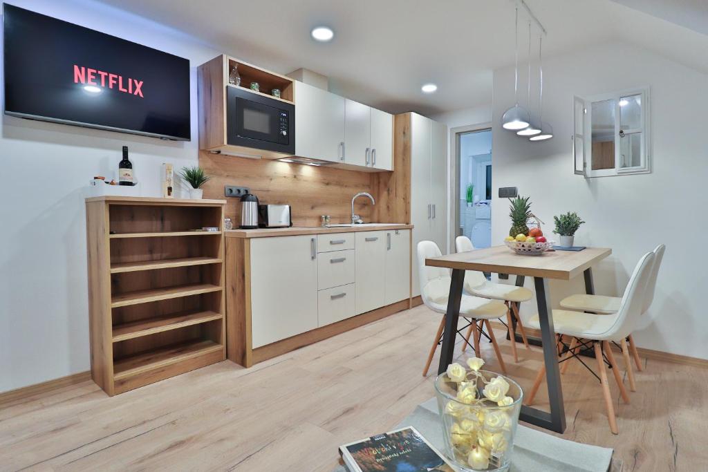 a kitchen and dining room with a table and a tv at Apartments Seventy Seven in Kranjska Gora