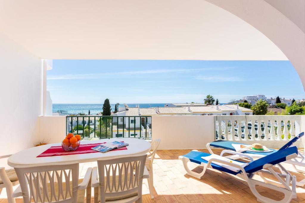 einen Balkon mit einem Tisch, Stühlen und Meerblick in der Unterkunft CoolHouses Algarve Luz , 2 Bed apartment w/ sea view, Blue Ocean View (4972/AL) in Luz