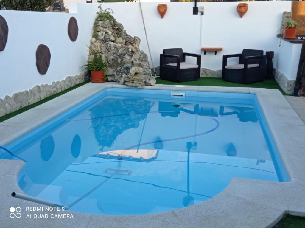 a swimming pool with blue water in a backyard at FINCA LOS CHATOS in Cádiz