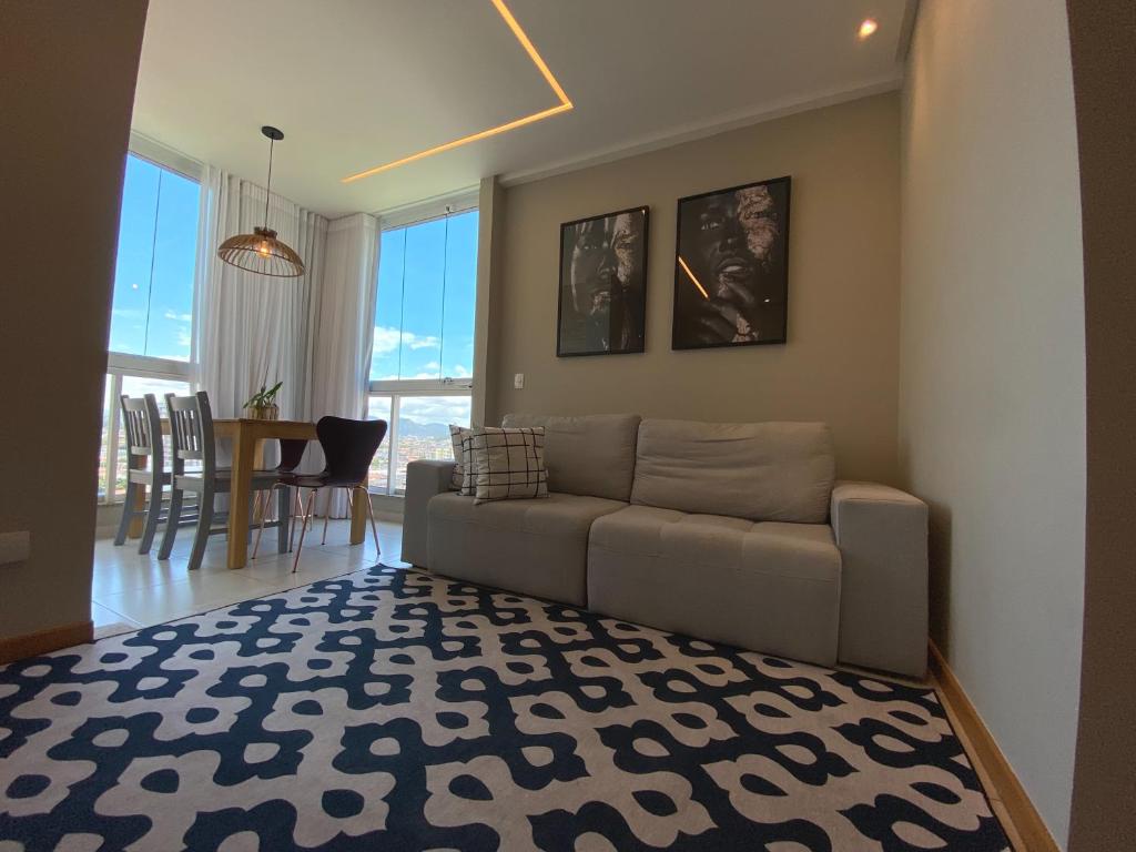 a living room with a couch and a dining room at ITAPARICA BEACH 24HRS in Vila Velha