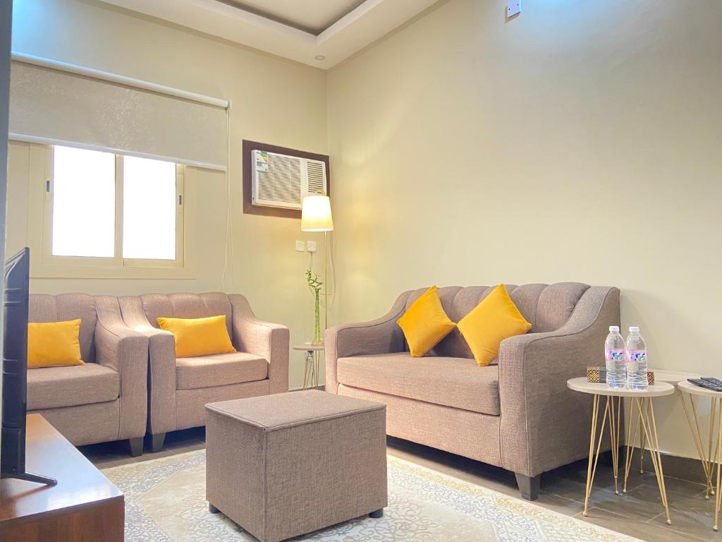 ein Wohnzimmer mit 2 Sofas und gelben Kissen in der Unterkunft الأراضي السبع in Yanbu